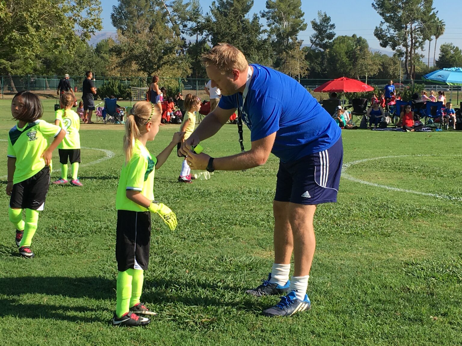 A man and young girl are playing soccer.