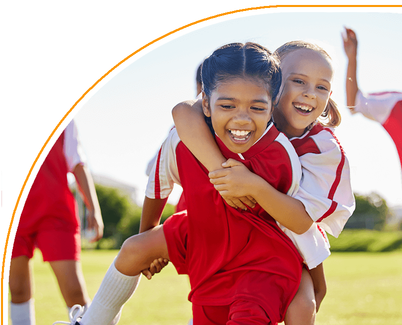 Two young girls are playing a game of soccer.