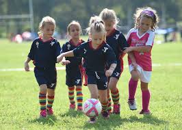 A group of young girls playing soccer on the field.